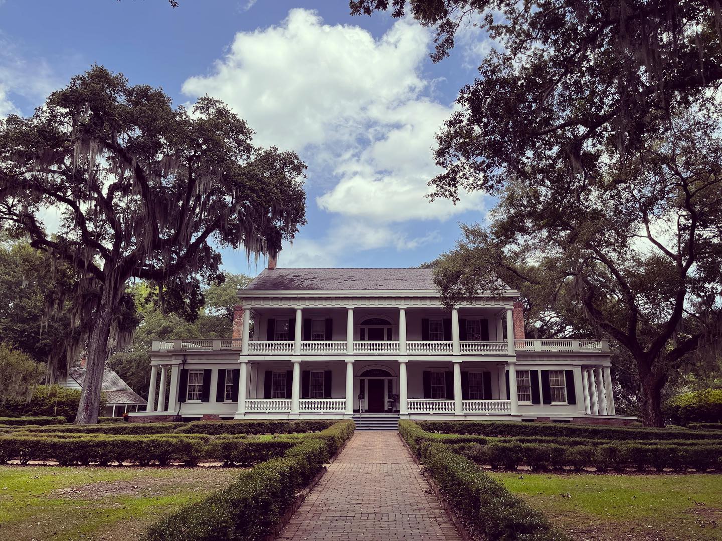 Wenn man die majestätische Allee auf der Rosedown Plantage in Louisiana entlangfährt, die 1835 von Daniel Turnbull und seiner Frau Martha Barrow Turnbull erbaut wurde, ist man sofort von der eigenartigen Atmosphäre verzaubert, die die gesamte Anlage ausstrahlt. Die Baumwollplantage, die einst von Hunderten von Sklaven bewirtschaftet wurde, bietet ein bitter-süßes Bild der Geschichte des tiefen Südens.